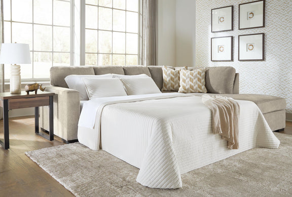 Gray sleeper sectional sofa opened into a bed with white bedding