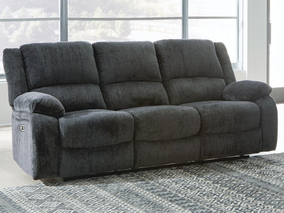 Dark gray reclining sofa with padded arms and three back cushions, side angle