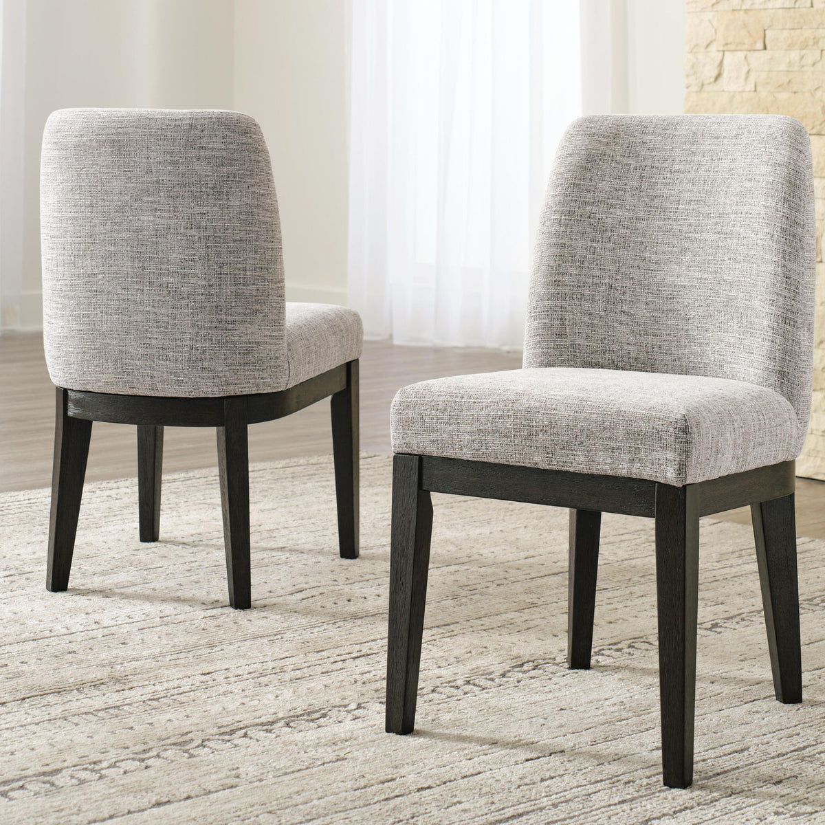 Two beige upholstered dining side chairs with dark brown legs, front 3/4 view