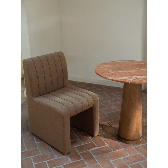 Light brown upholstered dining chair with channel back, wide seat, and curved arms