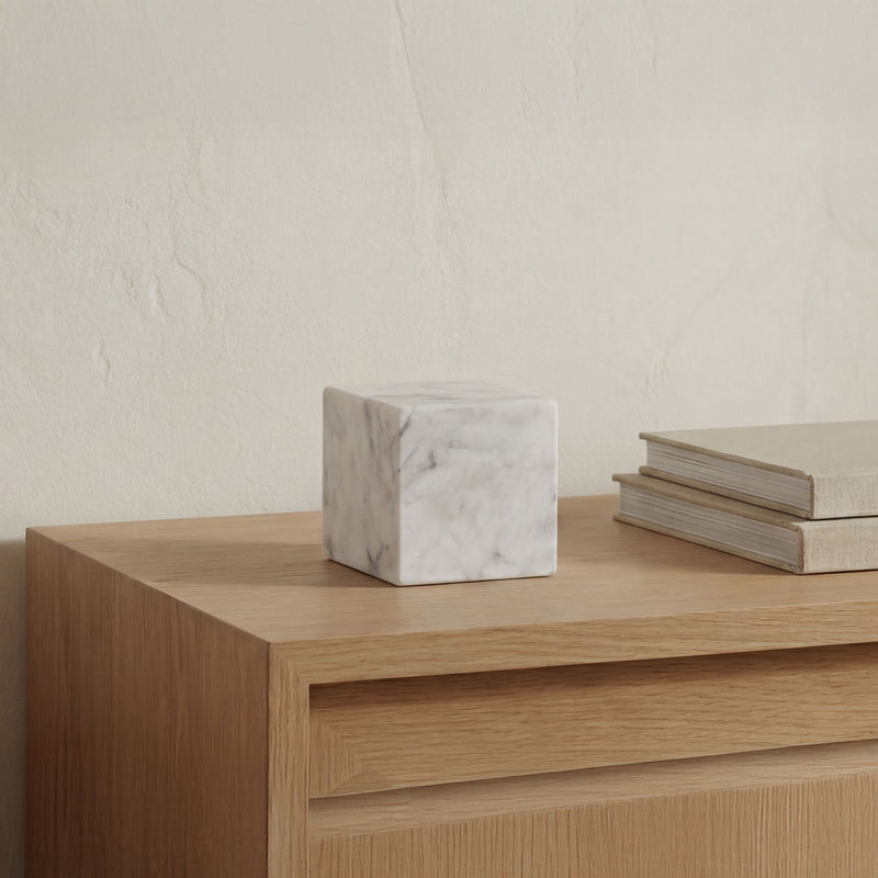 White marble cube accent with gray veining on tabletop