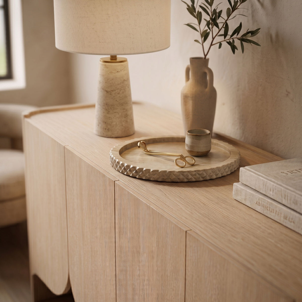 Beige marble tray on wooden vanity, textured scalloped edge visible.