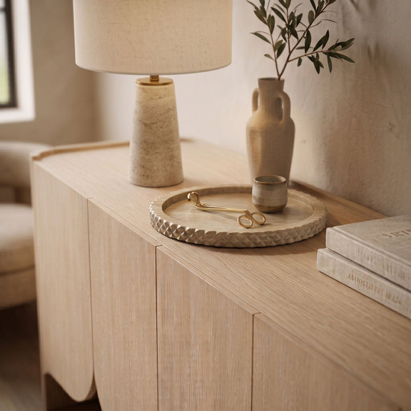 Beige marble tray on wooden vanity, textured scalloped edge visible.