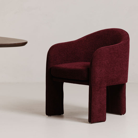 Plum upholstered dining chair with curved backrest and thick padded seat