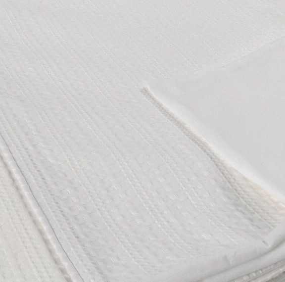 Closeup of white woven pillow sham fabric with textured diamond pattern