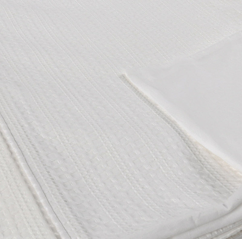 Closeup of white woven pillow sham fabric with textured diamond pattern