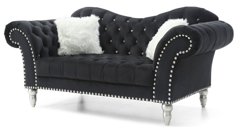 Black velvet round arm loveseat with tufted back, nailhead trim, and white faux fur pillows.