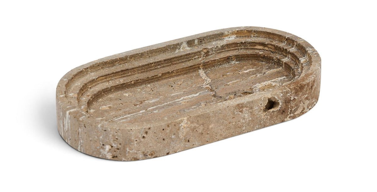 Brownish marble oval tray with concentric grooves and visible surface pits