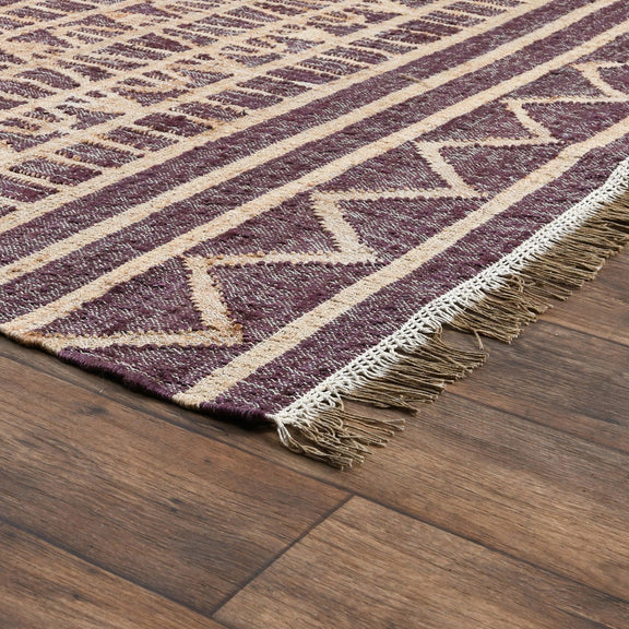 Distressed rug detail with purple geometric zigzags, cream stripes, and short fringe