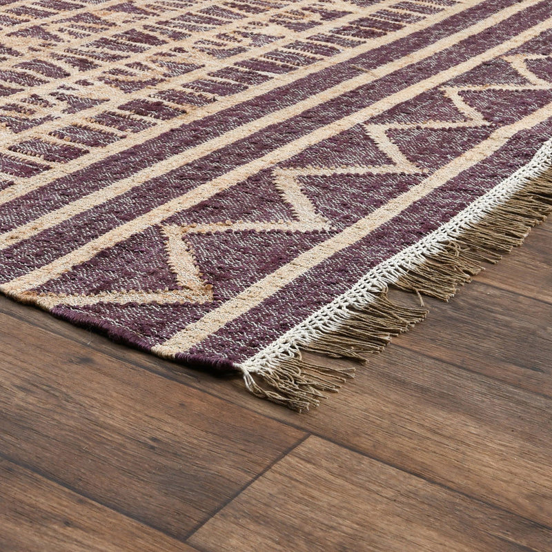Distressed rug detail with purple geometric zigzags, cream stripes, and short fringe