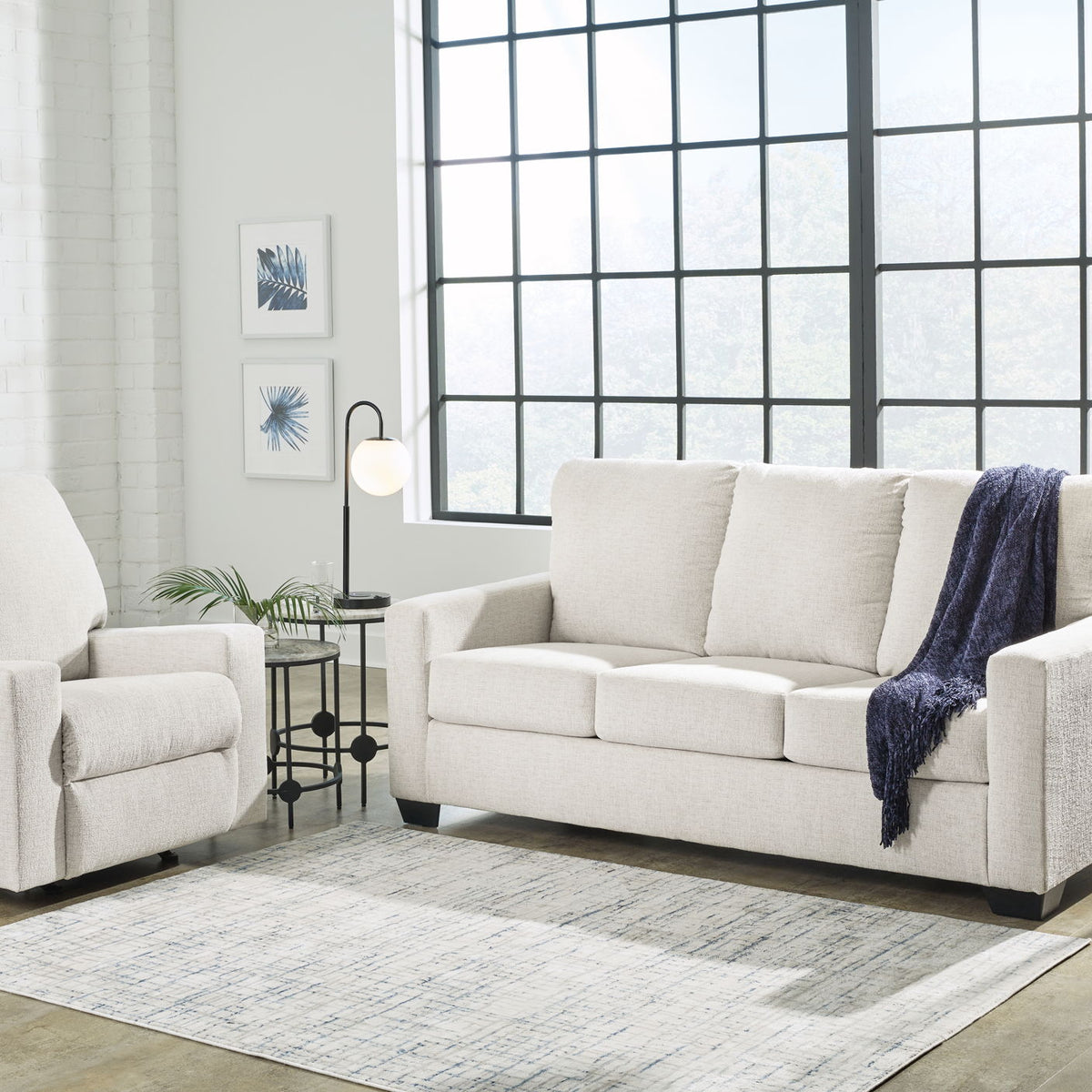 Beige fabric living room sofa with matching armchair, cushioned seats and rolled arms