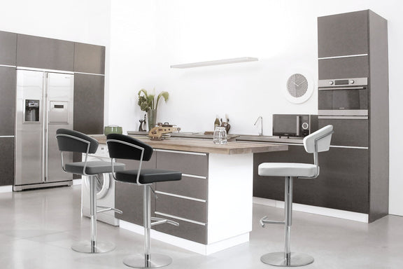 Stainless steel barstools with cushioned seats in a kitchen setting (multiple stools shown).