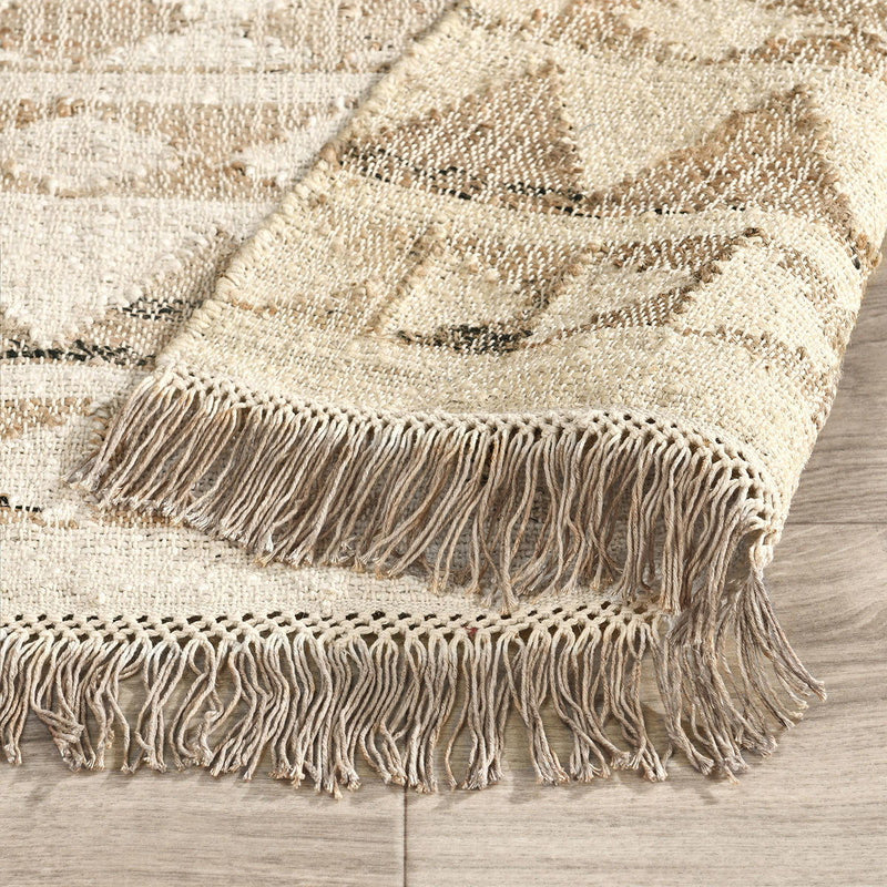 Solana rug in distressed ivory and natural with geometric pattern and short fringe border.