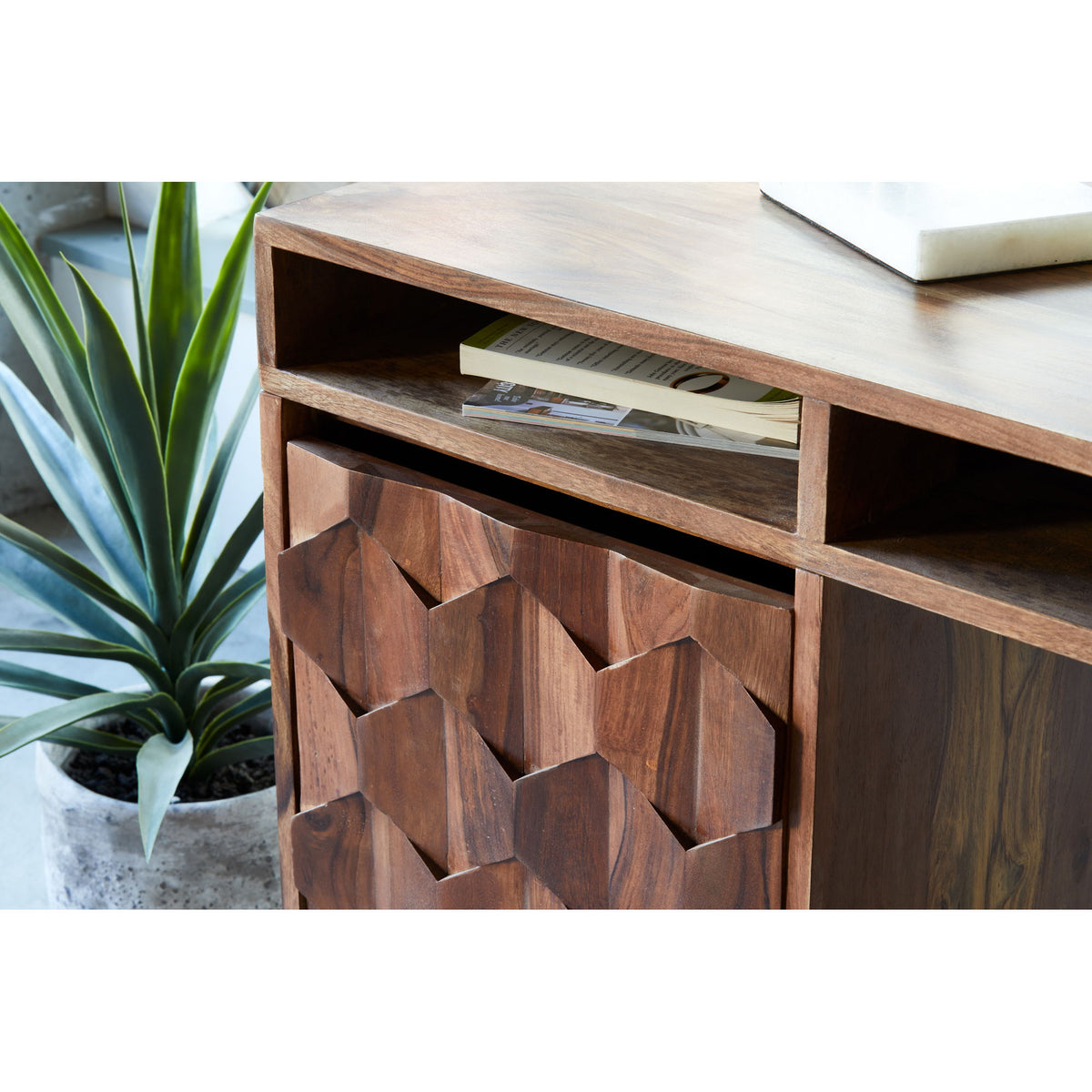 Caramel brown wooden desk front with geometric carved panels and a drawer opening