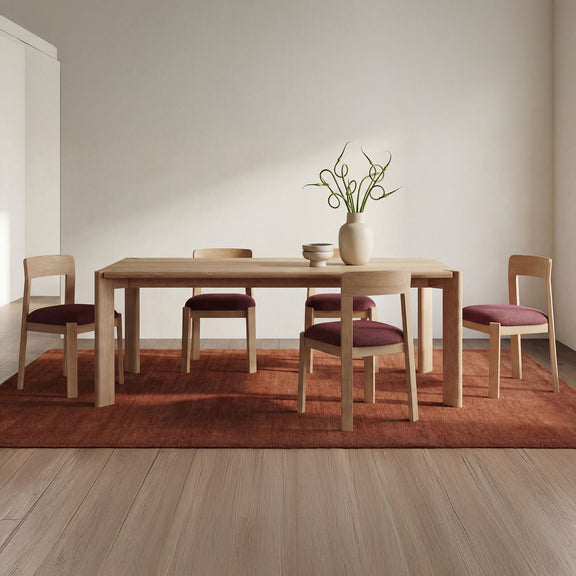 Natural brushed oak dining table with rectangular top and four legs, styled with chairs