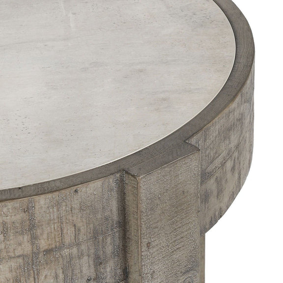 Close-up of concrete-look round tabletop edge on distressed gray wood base.