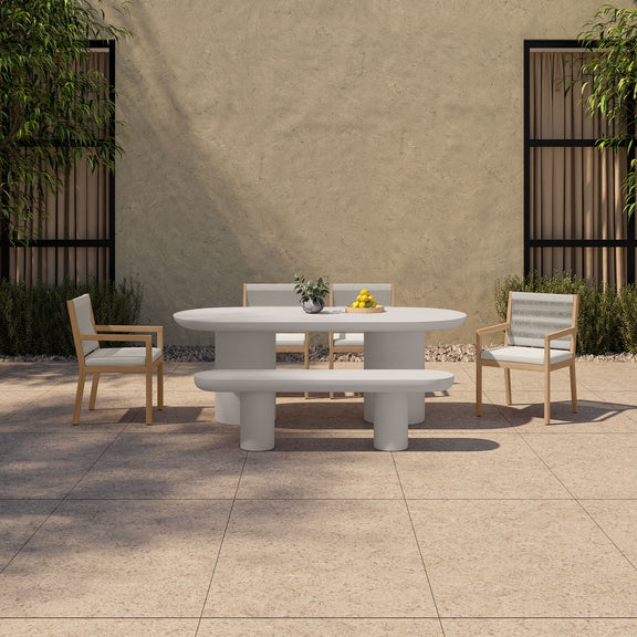 Cream oval dining table with pedestal legs in outdoor setting