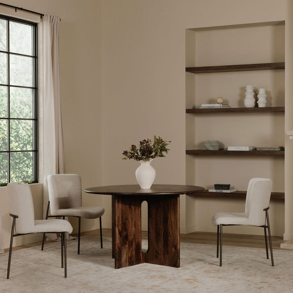 Beige upholstered dining chairs with slim dark metal legs around a dining table