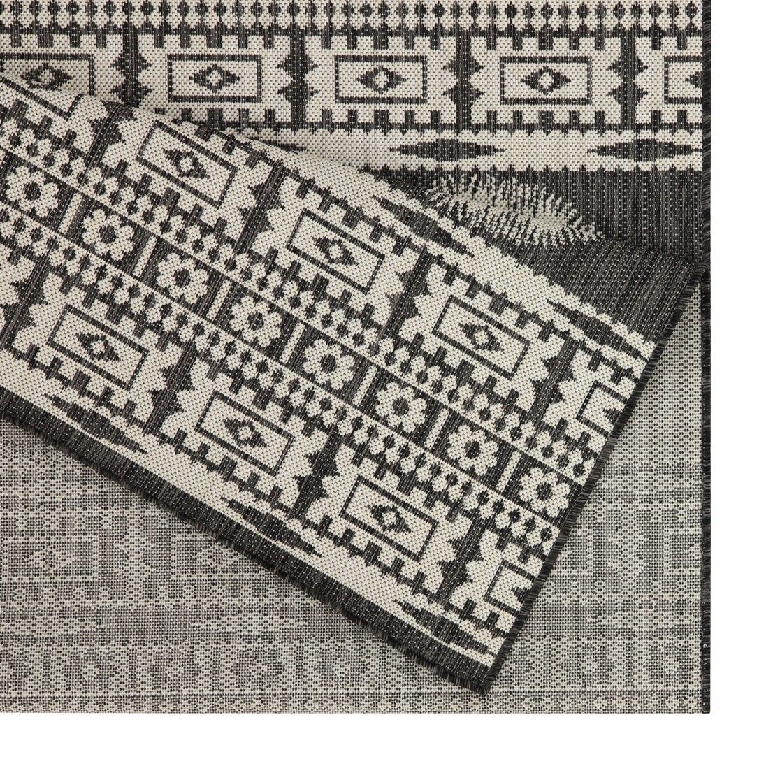 Close-up of gray and black polypropylene rug with woven geometric blocks pattern