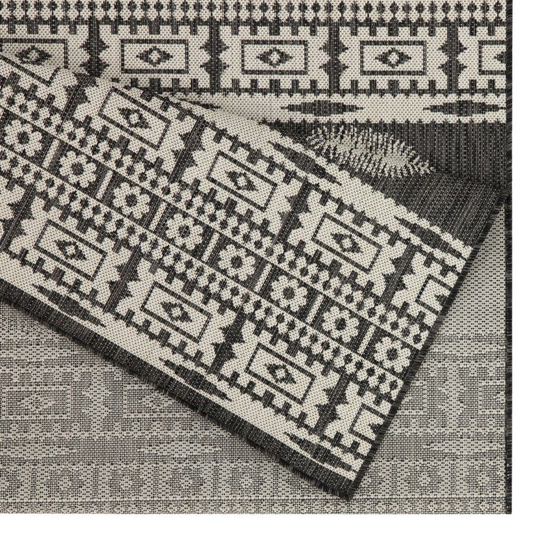 Close-up of gray and black polypropylene rug with woven geometric blocks pattern