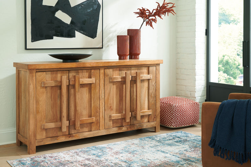 Natural wood accent cabinet with four panel doors and carved geometric details