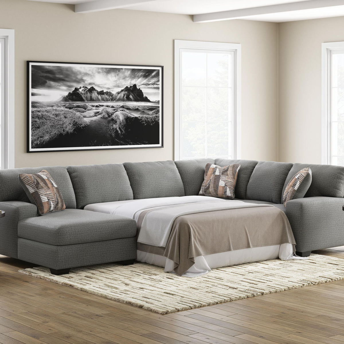 Gray sectional sofa with chaise sleeper, fitted throw blanket, and three back pillows