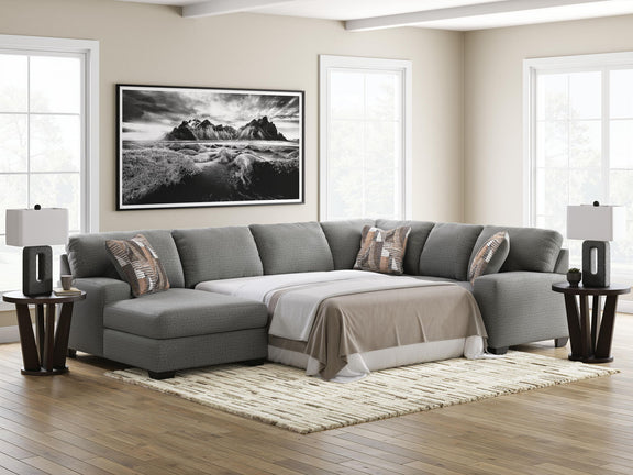 Gray sectional sofa with chaise sleeper, fitted throw blanket, and three back pillows