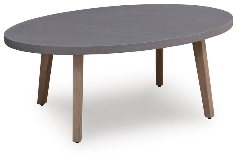 Gray oval cocktail table with solid top and four light wood tapered legs.