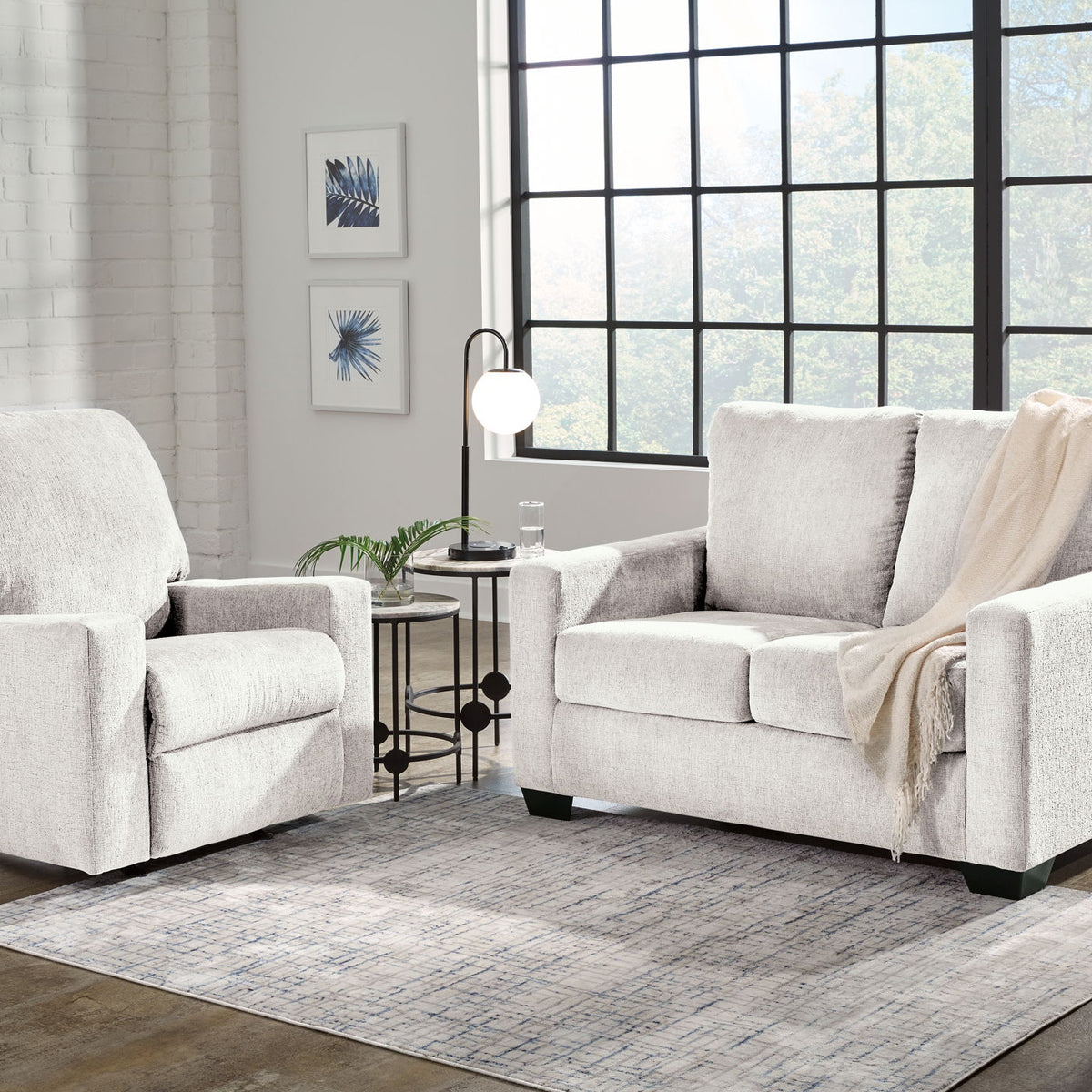 Beige fabric living room sofa with matching accent chair, throw draped over arm