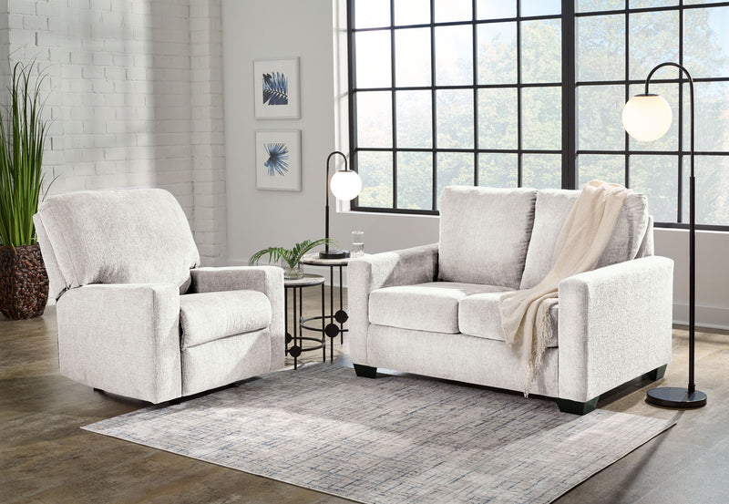 Beige fabric living room sofa with matching accent chair, throw draped over arm