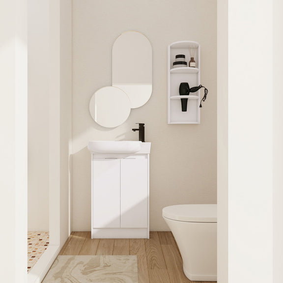 White freestanding bathroom vanity with oval sink and two cabinet doors, plus wall storage cabinet