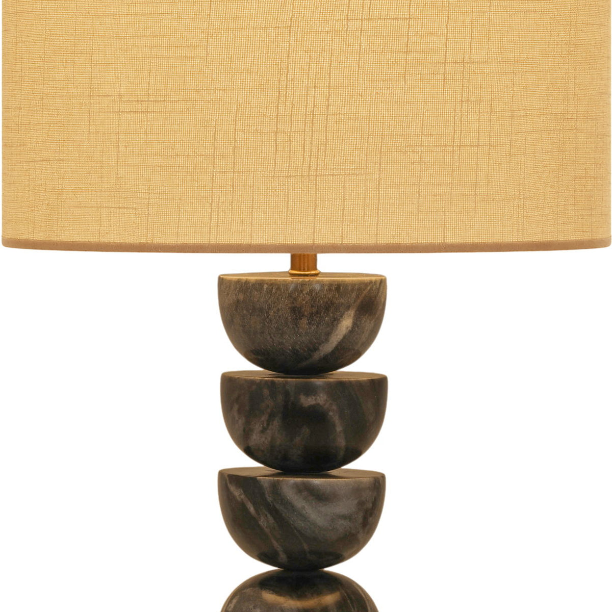 Table lamp with stacked dark marble base and tan fabric drum shade, brass accents