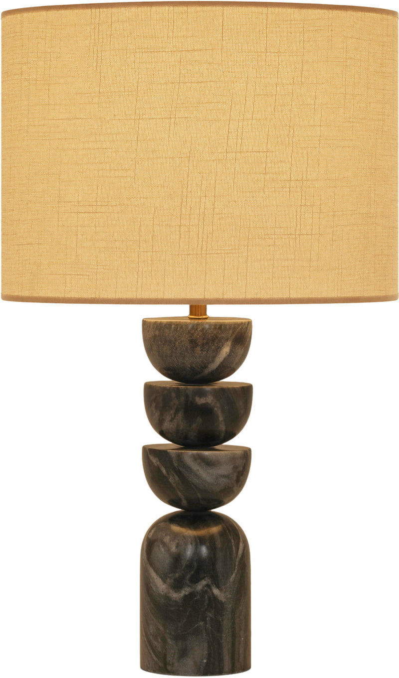 Table lamp with stacked dark marble base and tan fabric drum shade, brass accents