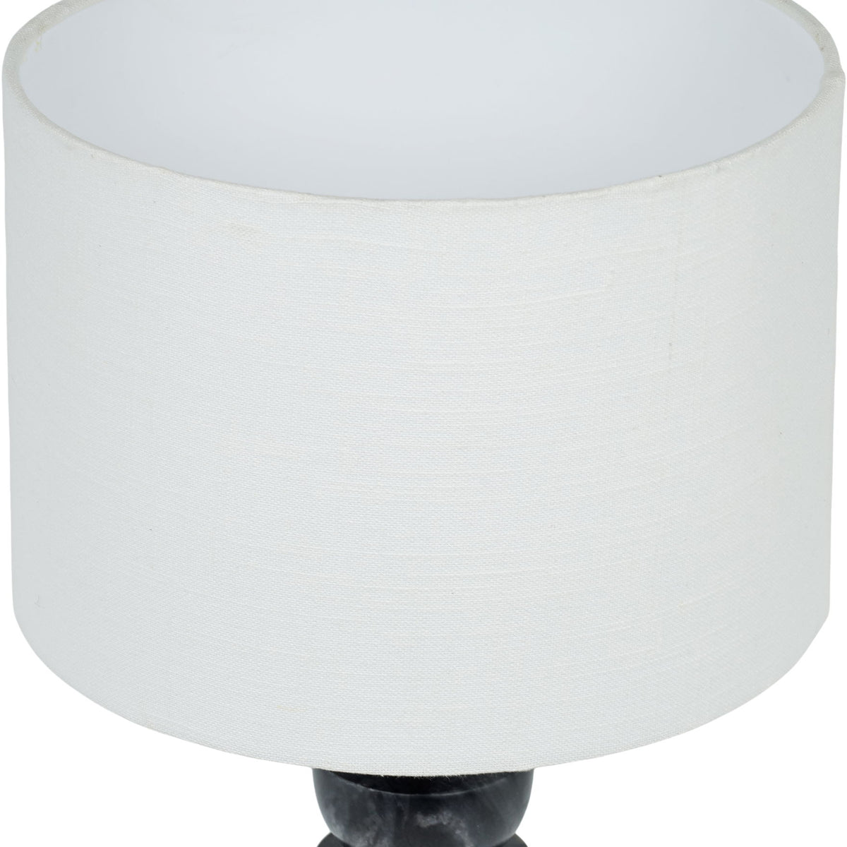 Table lamp close-up: white fabric drum shade over dark marble base with brass finial