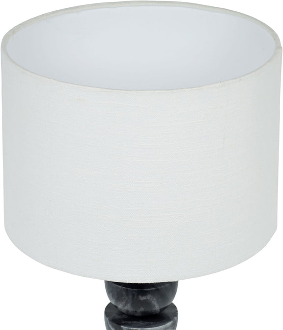 Table lamp close-up: white fabric drum shade over dark marble base with brass finial