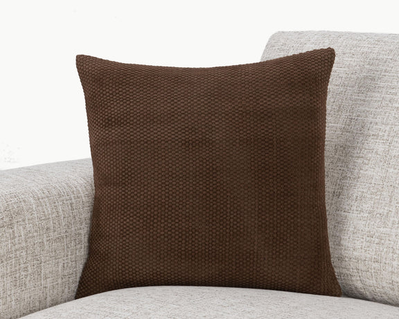 Coffee brown woven square pillow on light upholstered seating