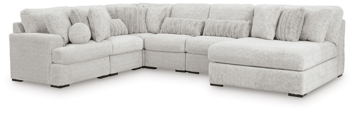 Light gray cuddle plush corner sectional with multiple seat cushions and ottoman block