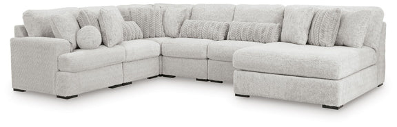Light gray cuddle plush corner sectional with multiple seat cushions and ottoman block