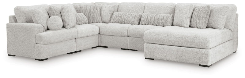 Light gray cuddle plush corner sectional with multiple seat cushions and ottoman block