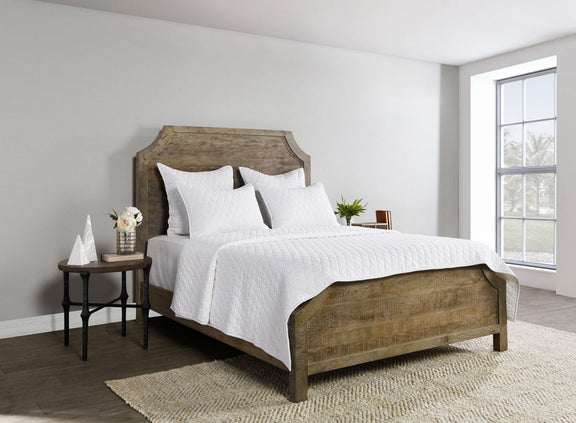 White diamond-quilt bedding set with quilt and four matching pillows on bed