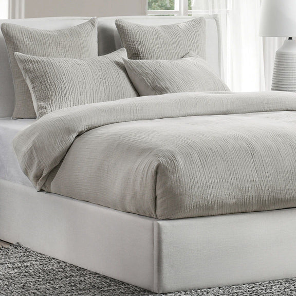 Gray textured duvet with matching pillows and shams on a bed