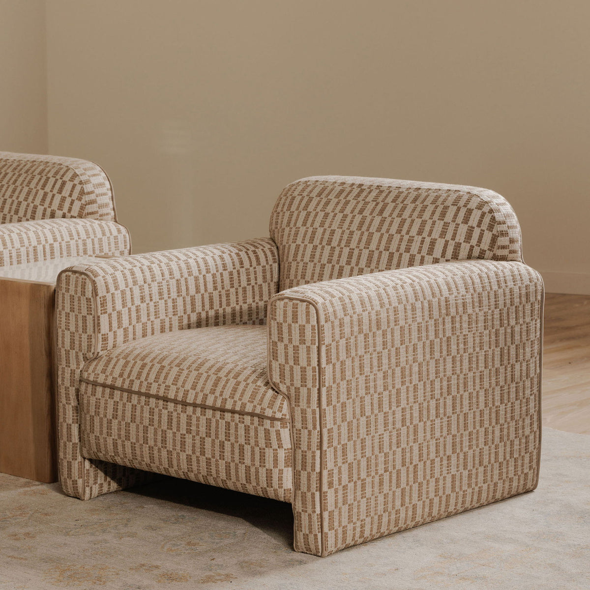 Taupe accent chair with geometric woven upholstery and wide boxy seat, side view