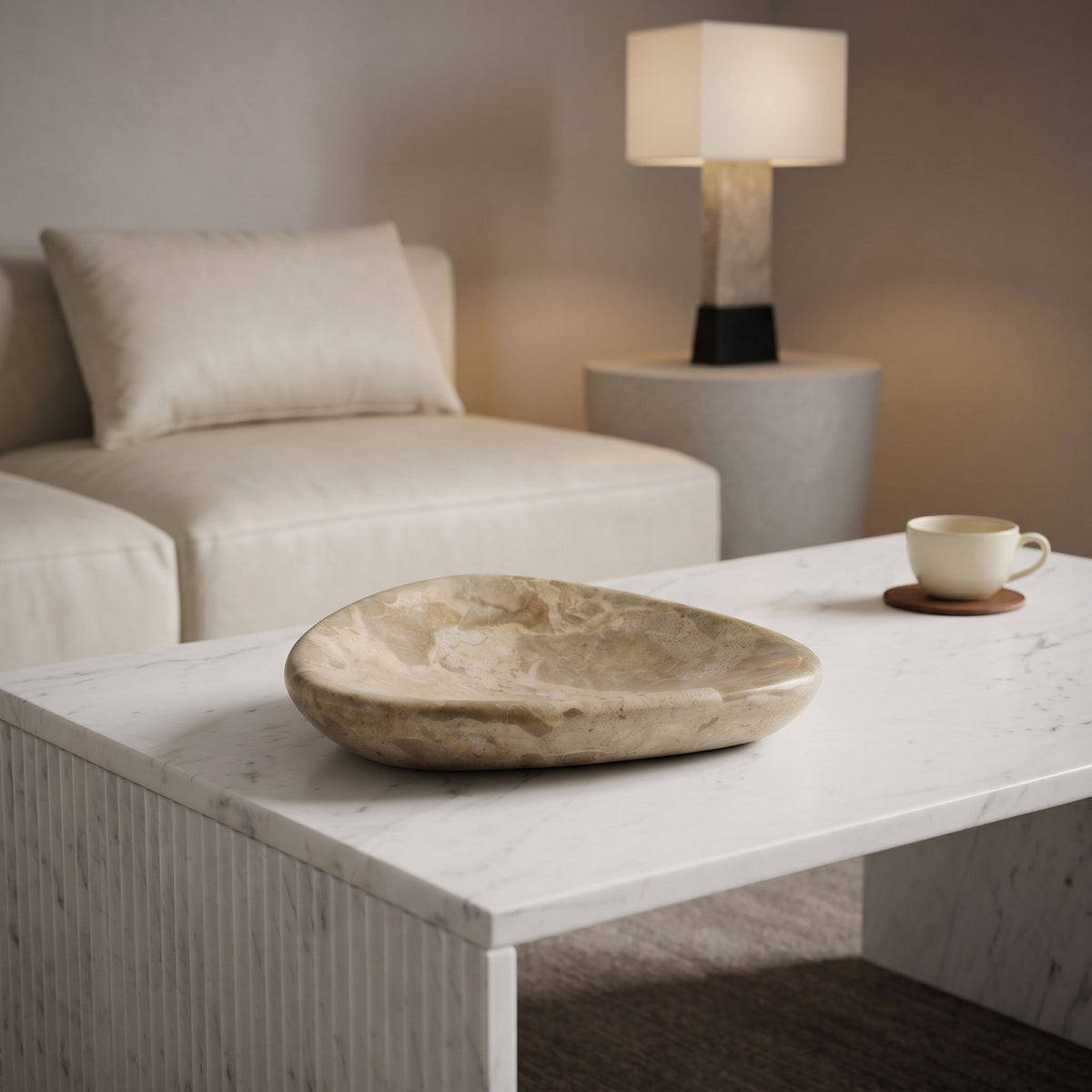 Beige marble bowl on white tabletop, shallow dish shape with natural veining.