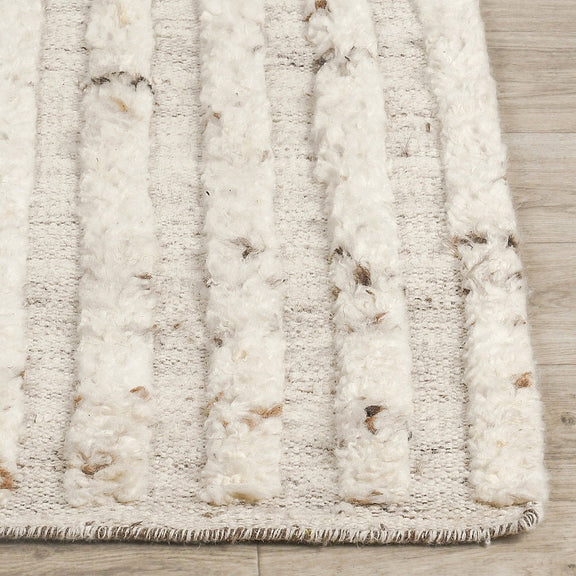 Ivory wool rug pile close-up with vertical raised texture and dark fleck accents