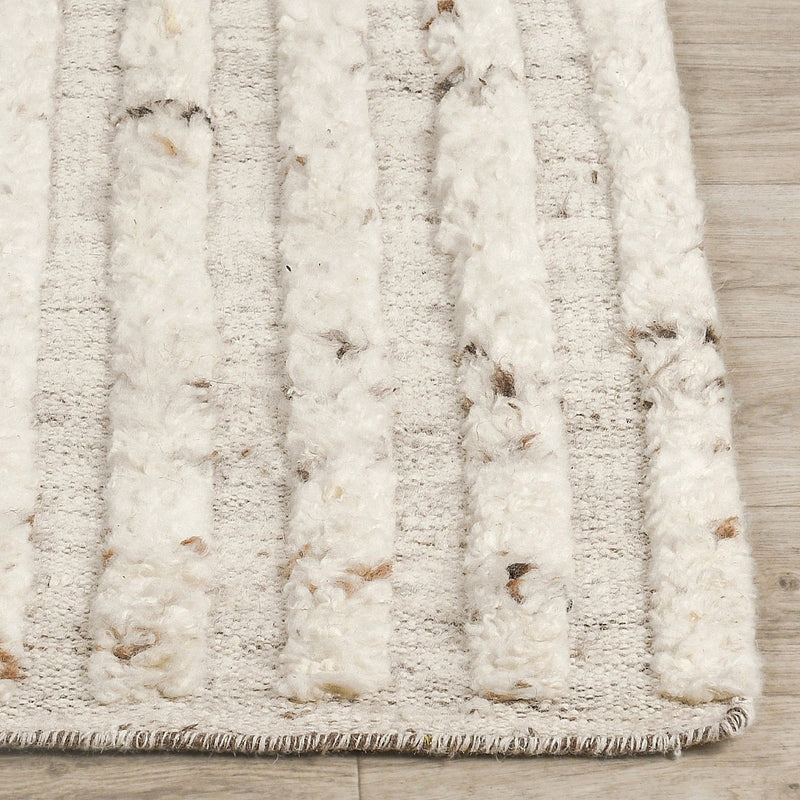 Ivory wool rug pile close-up with vertical raised texture and dark fleck accents