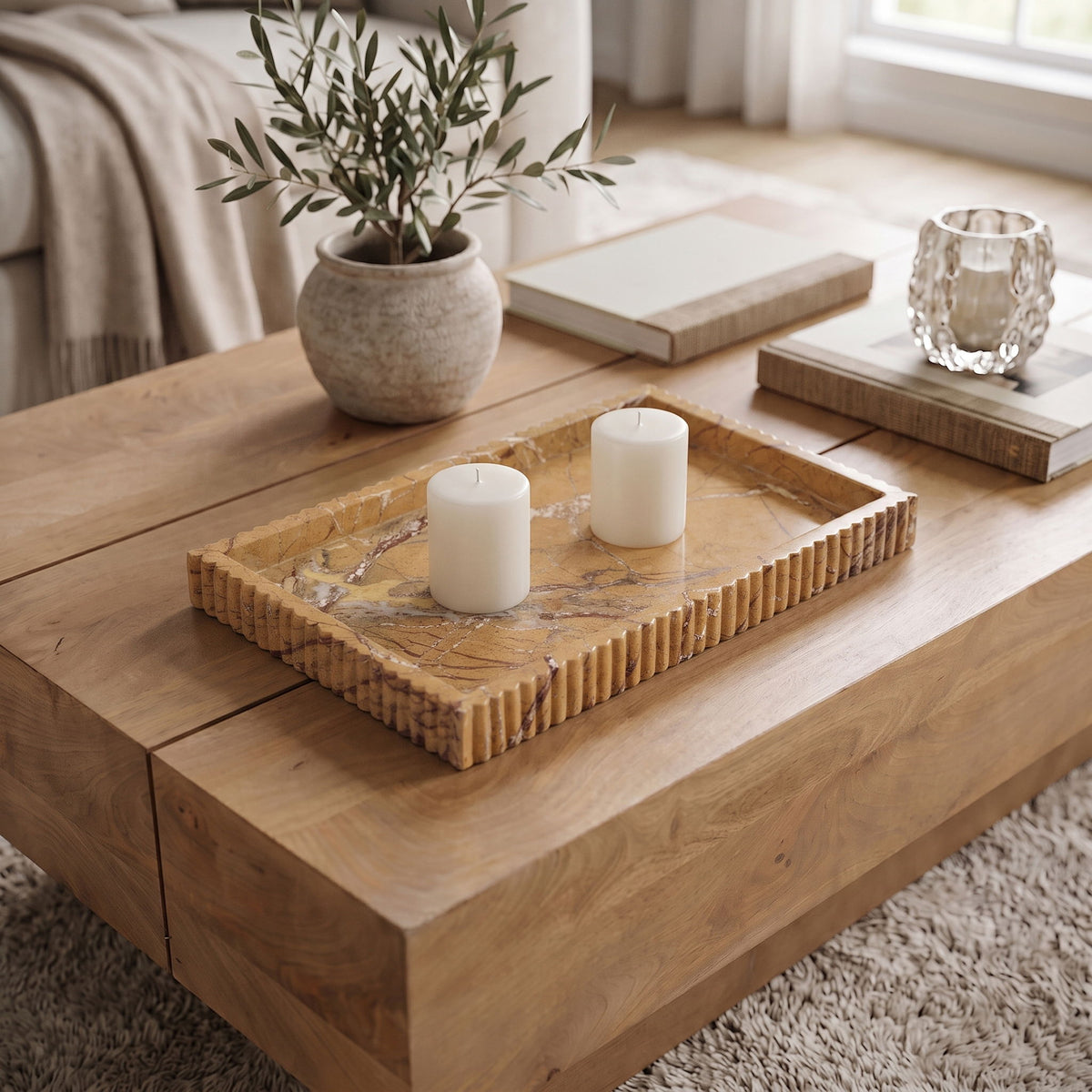 Tan marble tray with ridged sides holding two white pillar candles