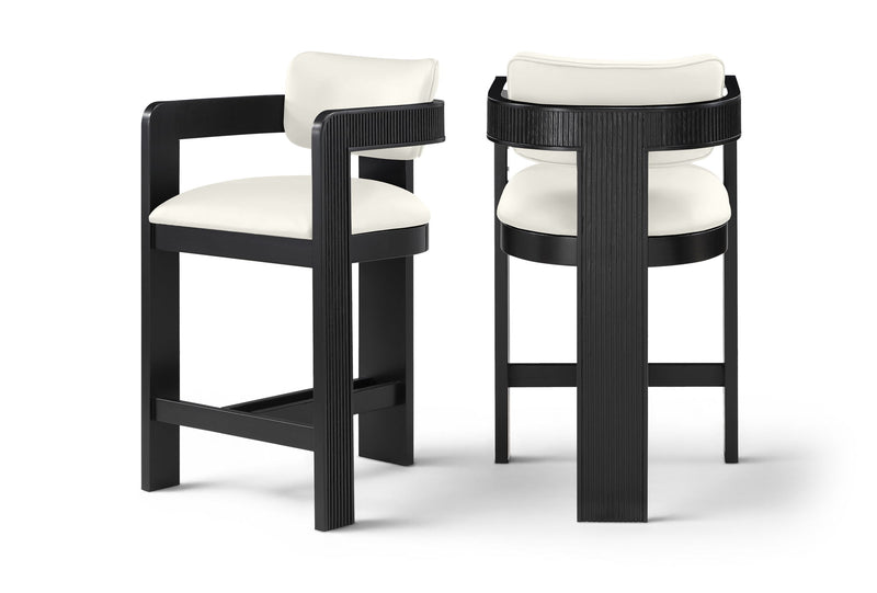 Two white vegan leather counter stools with fluted backs and black frames