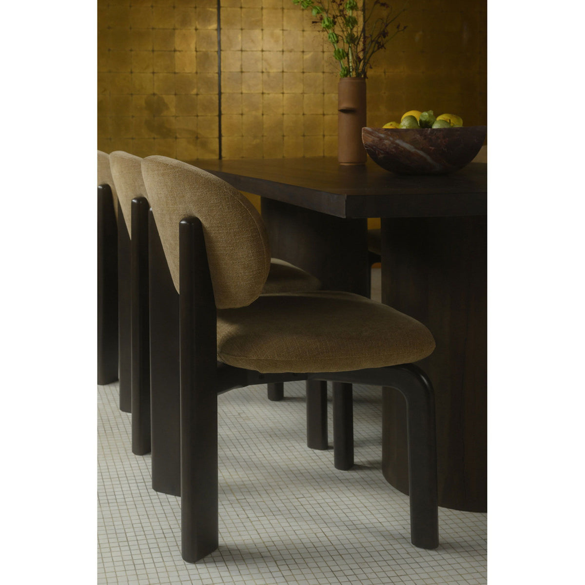 Tan upholstered dining chair with rounded back, dark brown tapered legs, side view