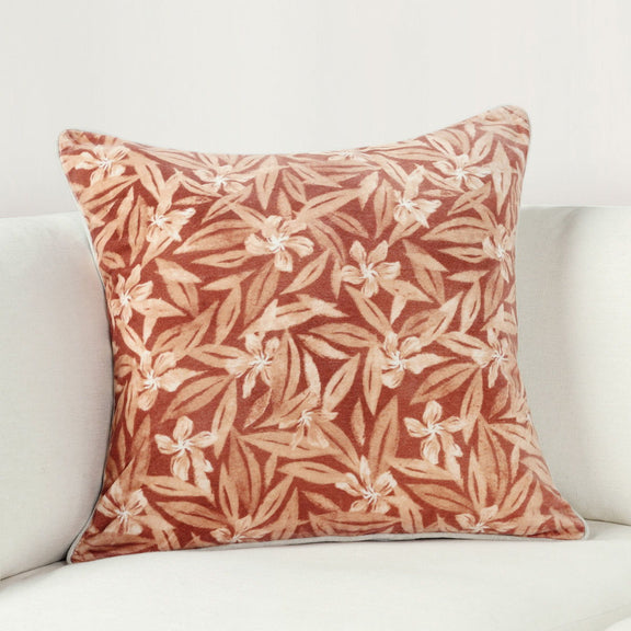 Rust and cream botanical print square throw pillow on light couch, 22x22 in