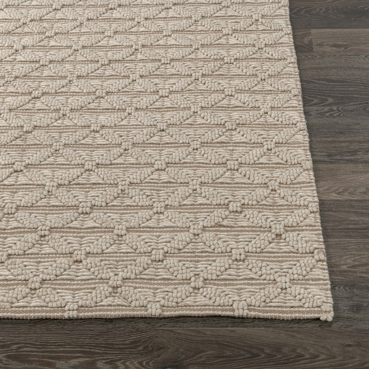 Ivory 2 ft x 3 ft rug with raised geometric trellis weave and textured fringed corner.